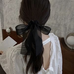 Elegant black organza oversized bow hair clip shown on model for back-of-head hairstyle