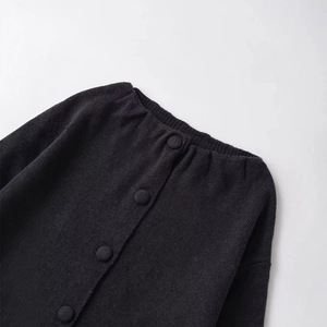 Gilet fin noir pour femme avec col rond et boutons sur un fond gris clair minimaliste