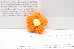 Macro shot of handmade orange and yellow milk cotton crochet flower accessory