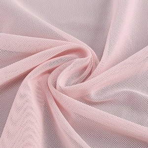 Vue macro du tissu en maille rose montrant le tissage fin et le drapé fluide