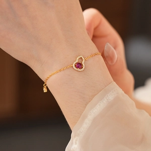 Detailansicht eines 18K vergoldeten Armbands mit rotem Rubinanhänger und Zirkonia