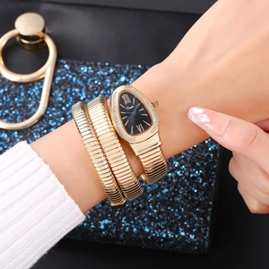 Close-up of golden snake wrap watch with crystal-encrusted dial and black roman numerals