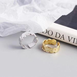 Detail of gold and silver open rings featuring a unique wrinkled foil texture finish