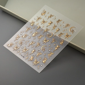 Macro view of gold fairy and moon nail stickers with embossed hot stamping details