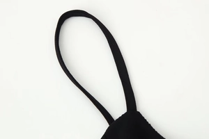 Detailed macro view of black adjustable spaghetti strap and stitching on backless dress