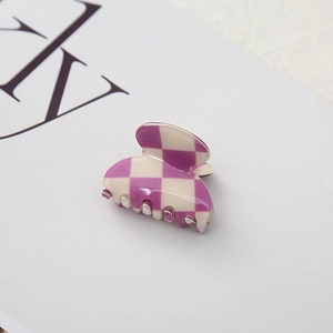 Close-up of a mini checkered claw clip in purple and beige with a glossy finish