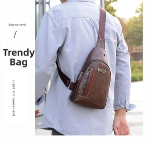 Outdoor shot of man wearing brown PU leather crossbody bag with red stitching detail