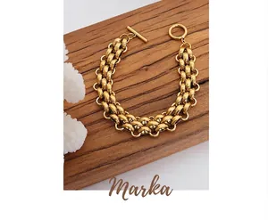 Macro detail of chunky gold plated chain bracelet with a classic toggle clasp design