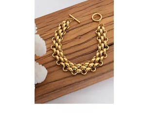 Macro detail of chunky gold plated chain bracelet with a classic toggle clasp design