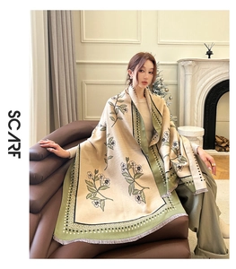Detail of floral beige and green cashmere scarf with tassel edge in elegant home setting