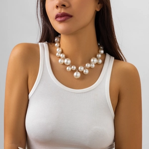 Detail of punk style layered necklace with oversized pearls and silver chain on model