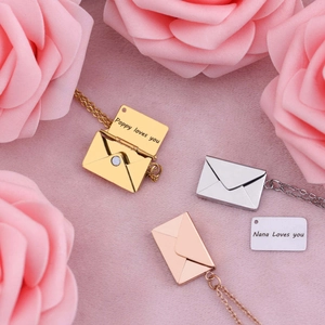 Golden and silver envelope locket necklaces with custom engraving set on pink flowers