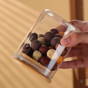 Square clear glass storage jar with airtight bamboo lid containing chocolate balls