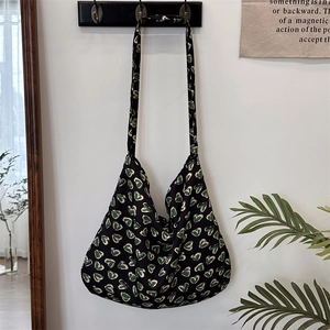 Detail of floral pattern on black shoulder bag hanging in a minimalist lifestyle setting
