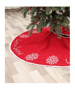 Detail of red knitted Christmas tree skirt with white Let it Snow embroidery and snowflakes