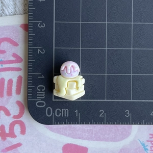 Mini pink resin ice cream accessory with colorful sprinkles on a scale measurement mat