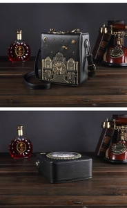 Detail view of clock-shaped vintage bag with embroidery and gold metal hardware