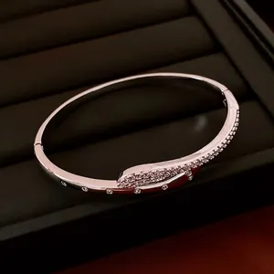 Silver-plated serpent bypass bangle with sparkling cubic zirconia on a black velvet display