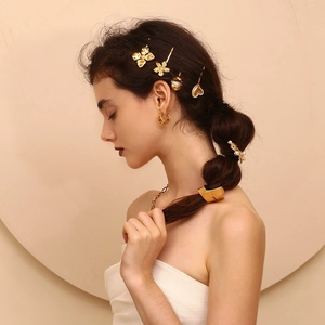 Detail of a 18K gold-plated stainless steel heart hair clip set on model's hair