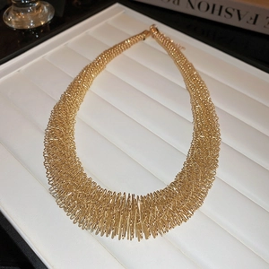 Detailed view of bold golden multi-layer spring choker necklace on white display