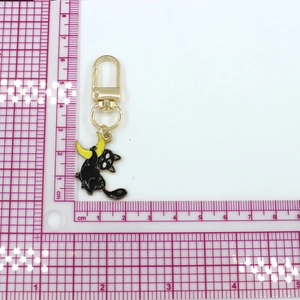 Detail view of a black cat on moon keychain pendant with size reference on white background