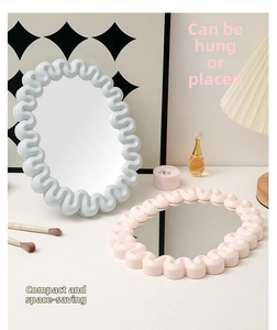 Detail of macaron blue and pink wavy-edged makeup mirrors on a minimalist vanity