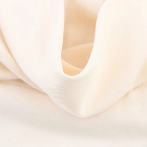 Detailed close-up of premium cream white midi dress fabric showing smooth texture and drape