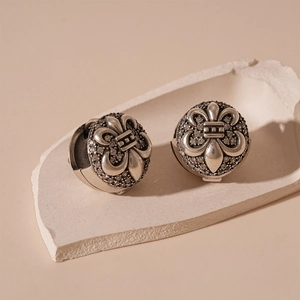 Detailed macro view of vintage silver iris beads with crystals on a stone surface