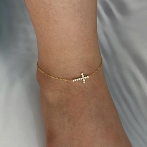 Minimalist gold stainless steel cross anklet with zircon inlay worn on ankle