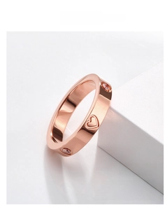 Detail showing rose gold titanium steel ring with heart carvings and inlaid white crystals