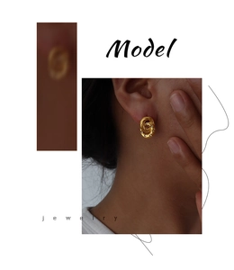 Close-up of golden twisted knot stud earrings with cubic zirconia inlays for women