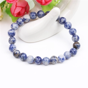 Macro view of blue and white tiger eye stone beaded bracelet on white hand display