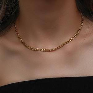 Dettaglio ravvicinato di una collana classica Figaro dorata indossata da una modella