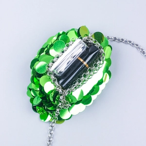 Internal view of green sequin mini bag showing lipstick and earphones storage space