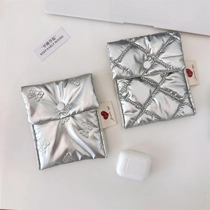Detailed view of silver metallic heart sanitary pouch with quilted patterns and snap button