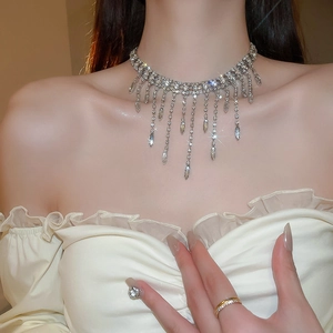Close-up of sparkling rhinestone fringe necklace with teardrop pendants on a model