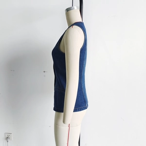 Détail du gilet en jean bleu foncé sur mannequin avec coutures latérales et poches