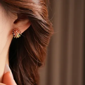 Colorful zircon flower stud earrings in gold setting worn by a female model