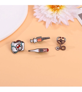 Detail of medical enamel pins set featuring a red first aid kit and syringe icons