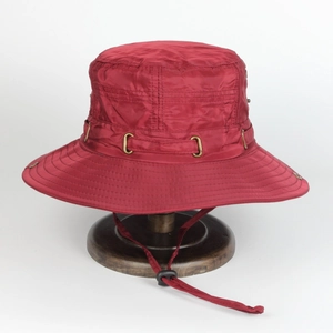 Detail of dark red wide brim sun hat with adjustable drawstring on wooden stand