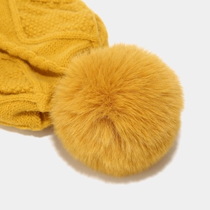 Winter yellow knit beanie hat with large faux fur pompom for warm outdoor protection