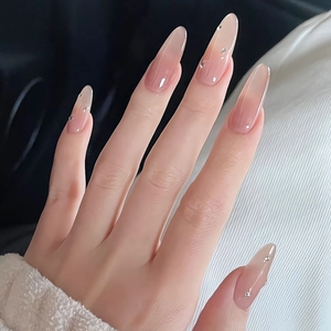 Detail of nude gradient press-on nails in long almond shape with small rhinestone accents