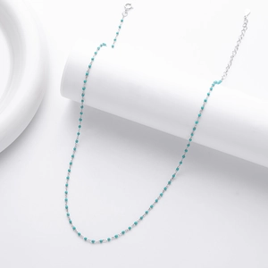 Close-up of a delicate S925 silver necklace featuring vibrant turquoise beads on a fine chain