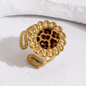 Dettaglio anello dorato a forma di girasole con motivo leopardato su pietra