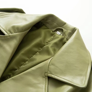 Detailed close-up of green leather coat lapel showing premium stitching and texture