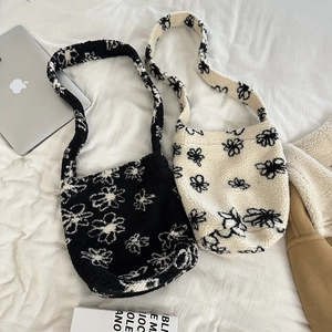 Close-up of fluffy sherpa tote bag with floral patterns on soft wrinkled fabric