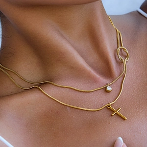 Double-layered 18K gold-plated necklace with cross pendant and white zircon on a model
