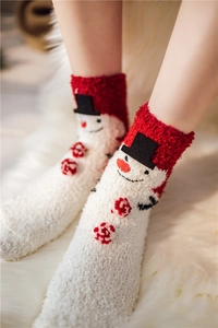 Close-up of coral fleece Christmas socks featuring 3D snowman design and plush texture