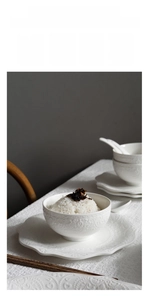 Macro shot of white ceramic tableware with elegant embossed patterns and smooth finish