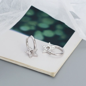 Artistic detail of 925 sterling silver star earrings with sparkling zircon inlay